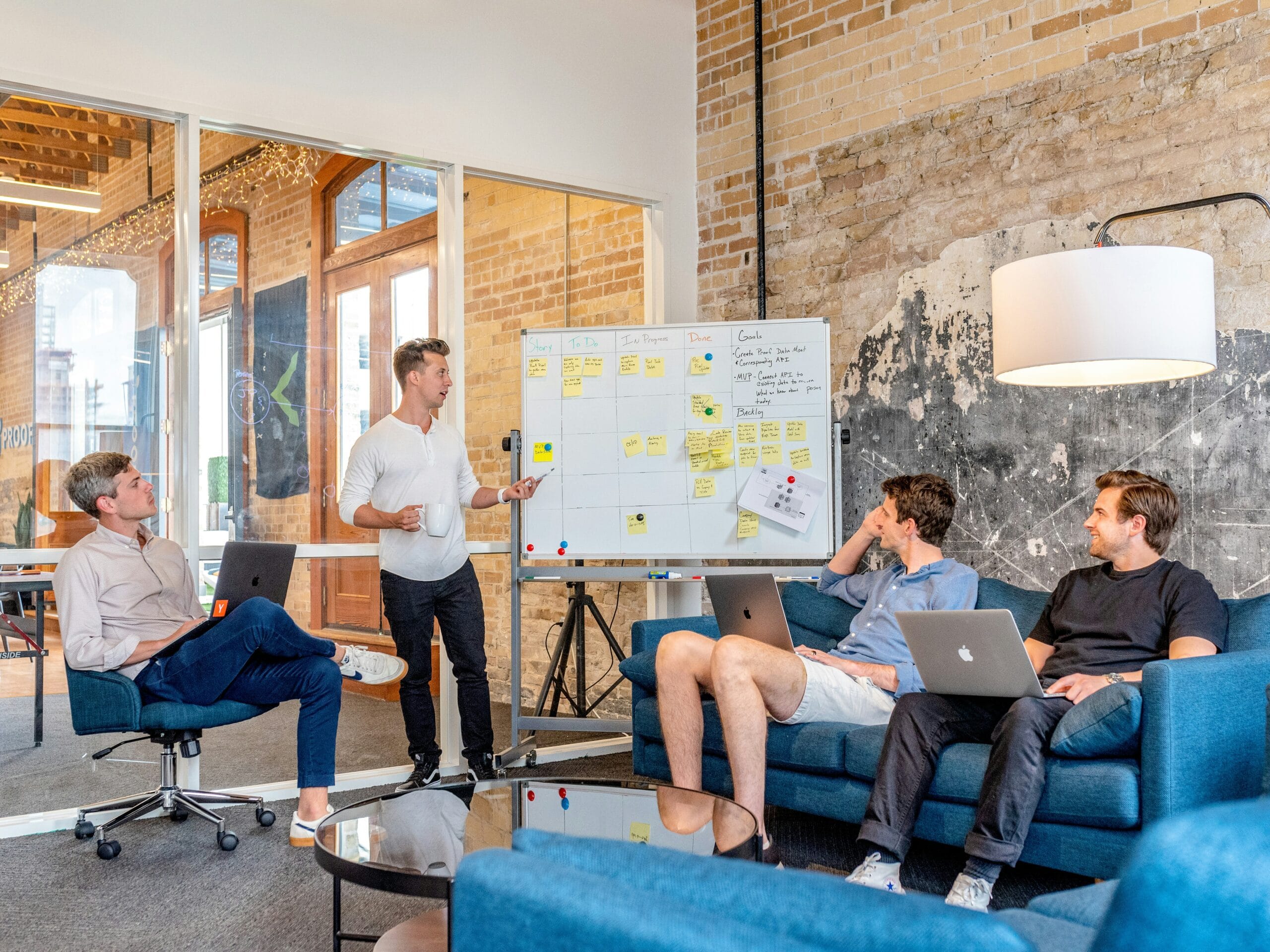 three men sitting while | Eddy Andrews Marketing three men sitting while using laptops and watching man beside whiteboard